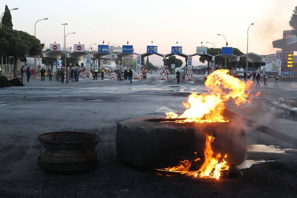 Barricada de neumáticos quemados en uno de los accesos a MercaBarna, Barcelona.