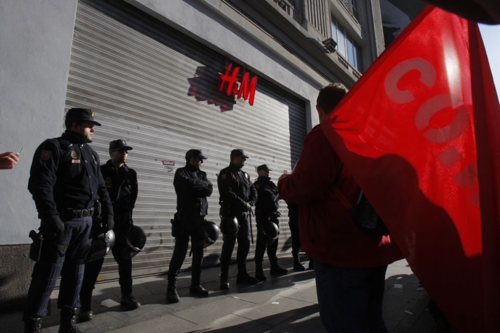 Policías antidisturbios vigilan una tienda en el centro de Madrid.