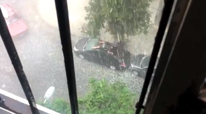 Un hombre se arroja sobre su coche para protegerlo del granizo 1