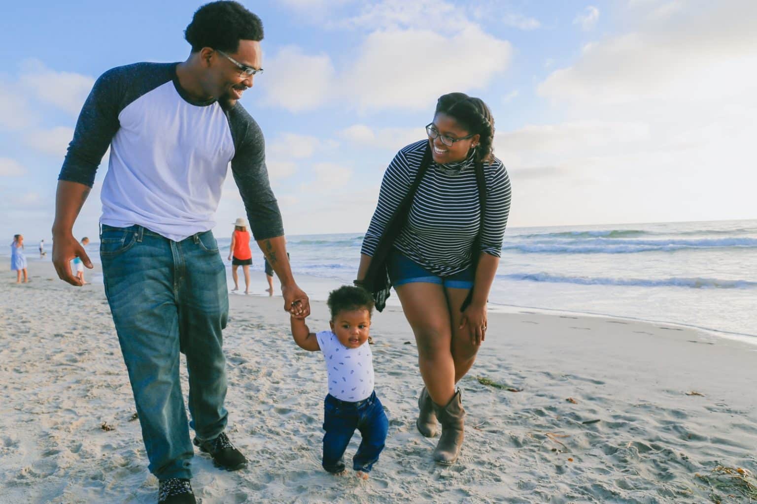 Reconocimiento de la nacionalidad española a una menor nacida en en tránsito man in black and white striped long sleeve shirt holding baby in white shirt on beach